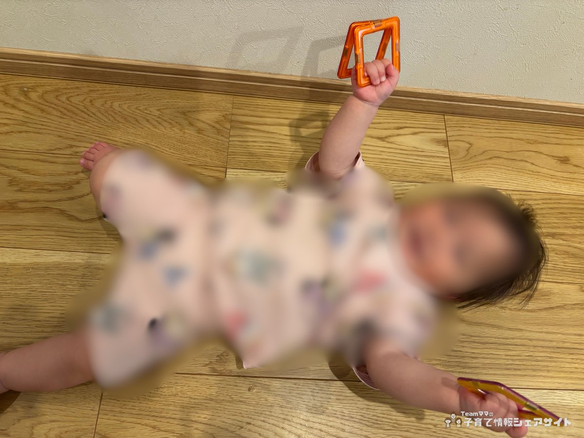 0歳の赤ちゃんがMAGFORMERS マグフォーマーの三角ピースを手に取って遊んでいる様子