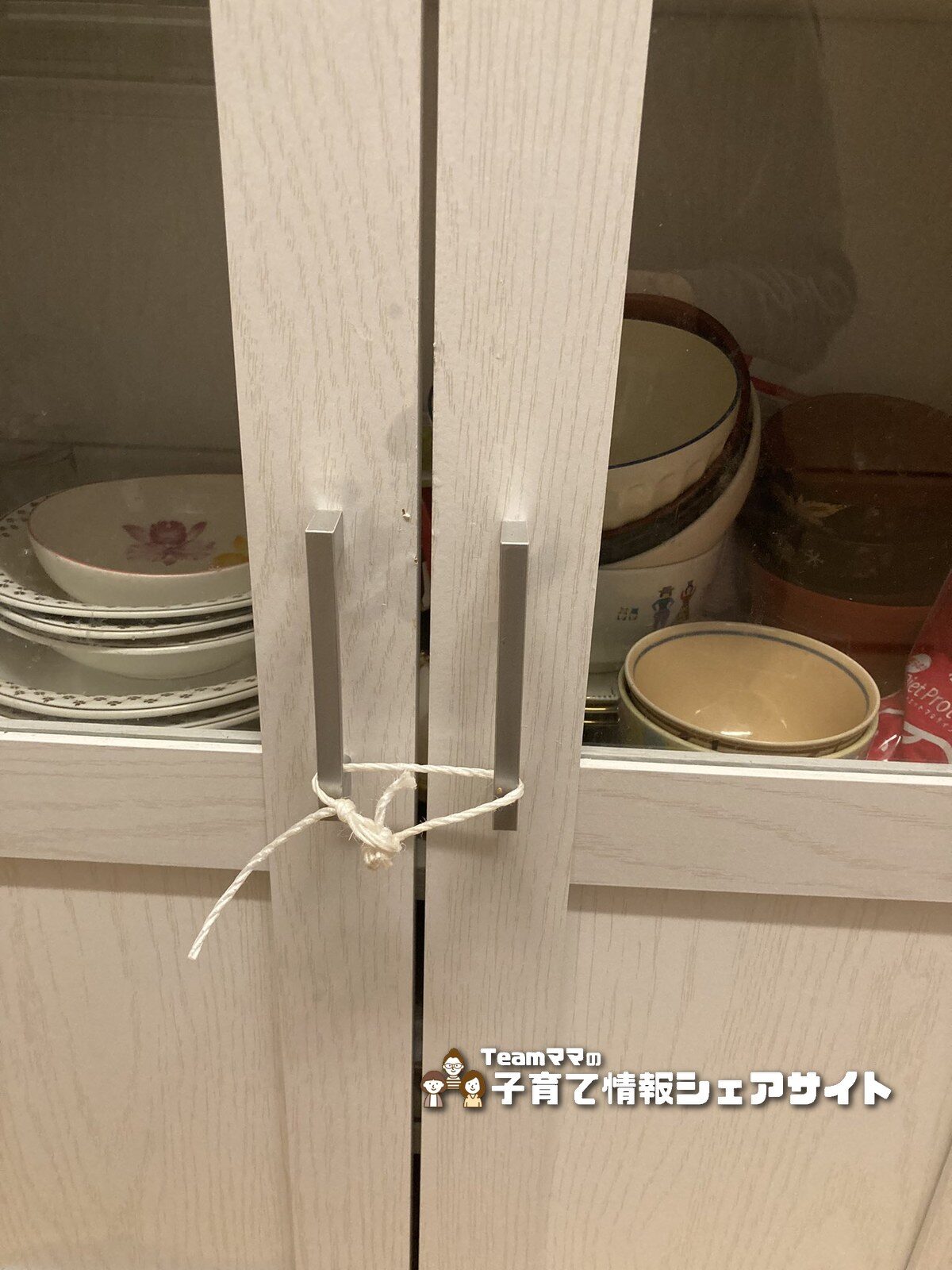 食器棚の取手を白い紐で結んで開けられないようにした応急処置の様子