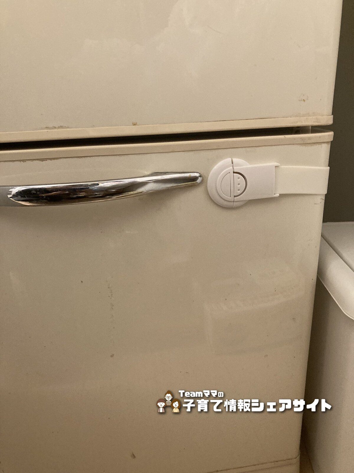 冷蔵庫の扉に取り付けた100均のチャイルドロック。ボタンを押すと簡単に解除できるタイプ