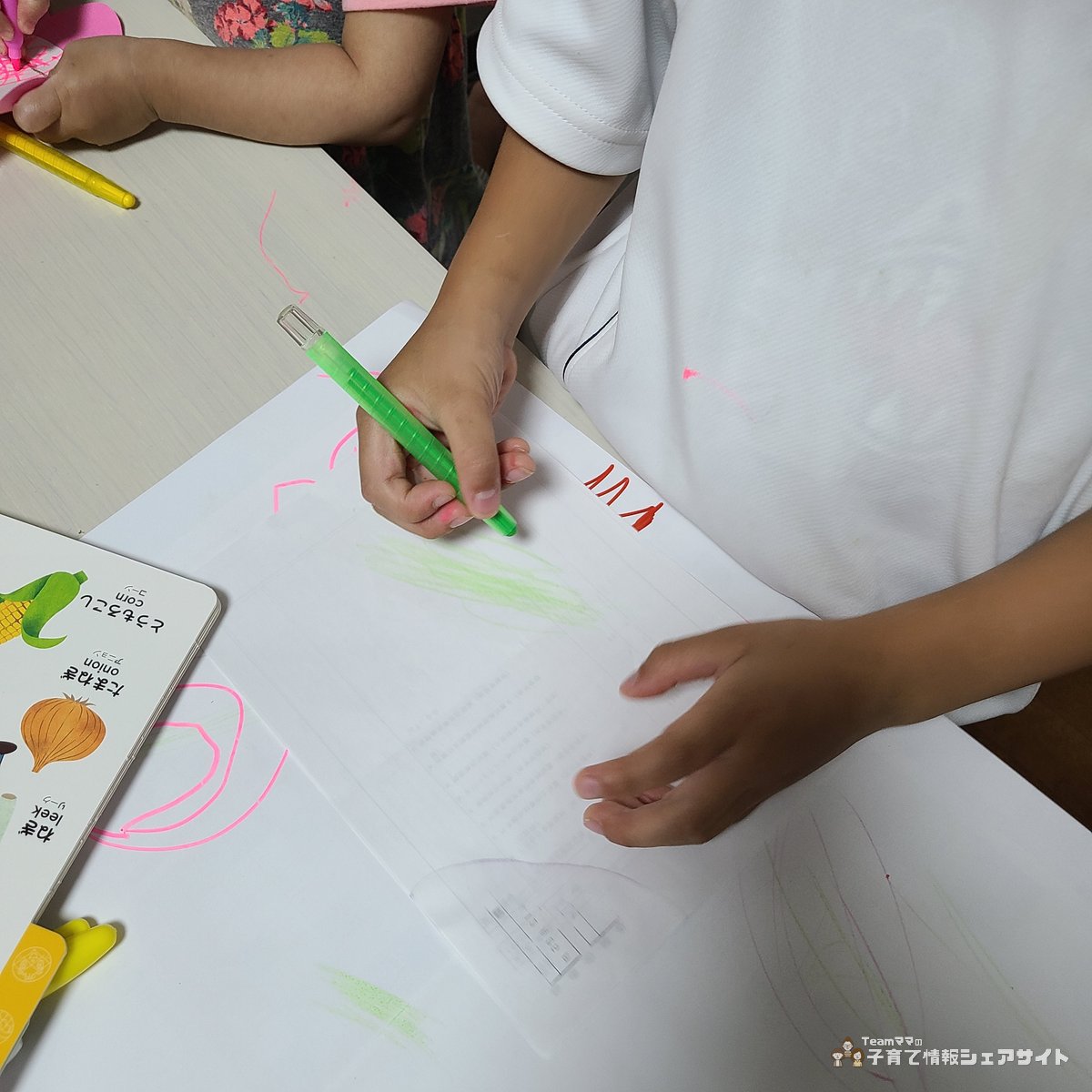 子どもが自由帳にダイソー 回すと芯が出るクレヨンで自由にお絵描きをしている様子