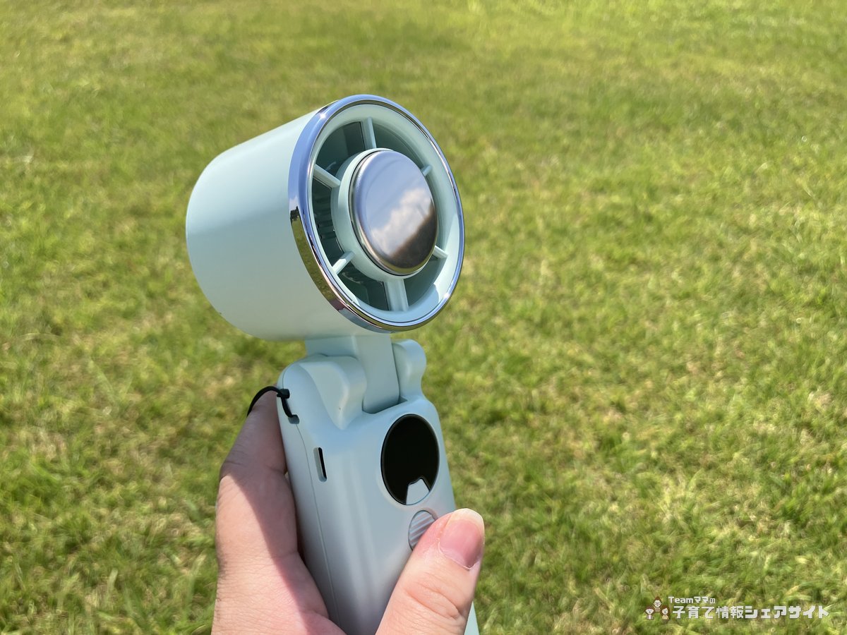 冷却プレートつきハンディファンを手に持って正面から見たところ 中央に丸い金属プレートが見える